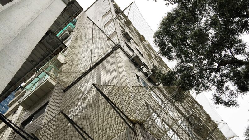 部分大樓外牆因磁磚掉落架設防護網，不僅不美觀，也只是治標不治本。