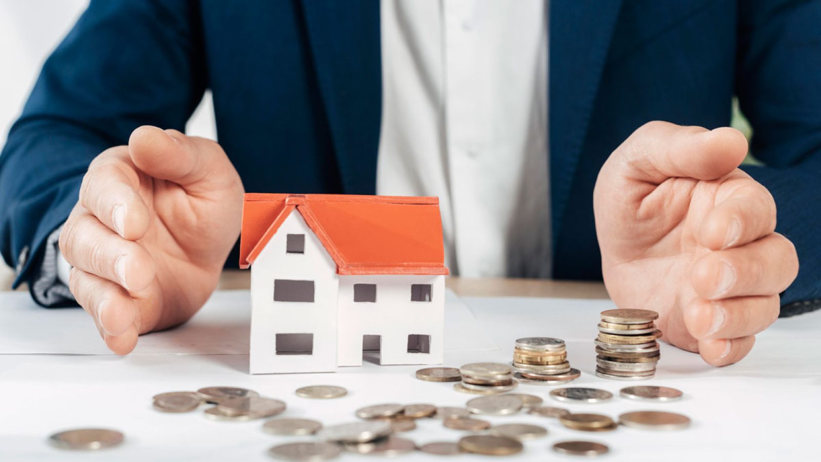 close-up-hands-with-coins-house