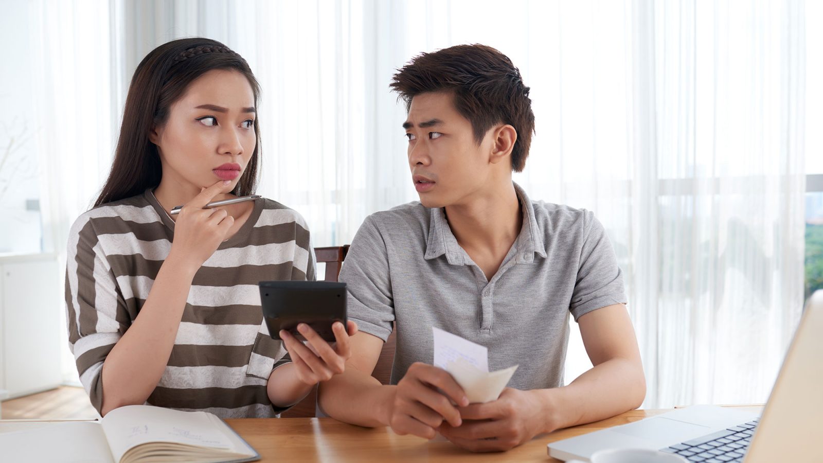 unhappy-young-family-calculating-expenses-going-bankrupt